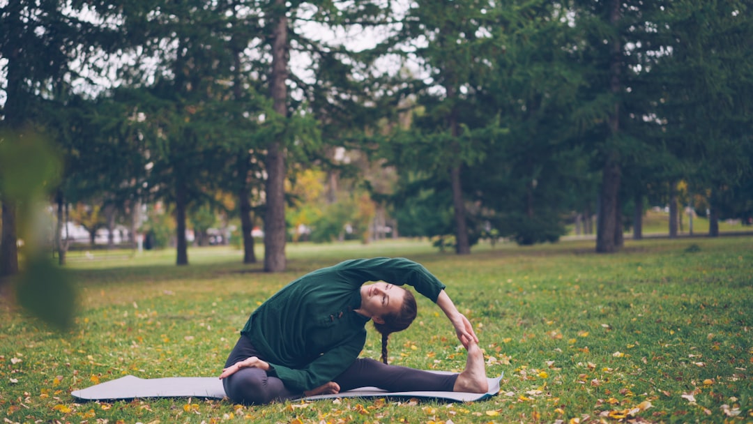 Woman stretching on yoga mat in park